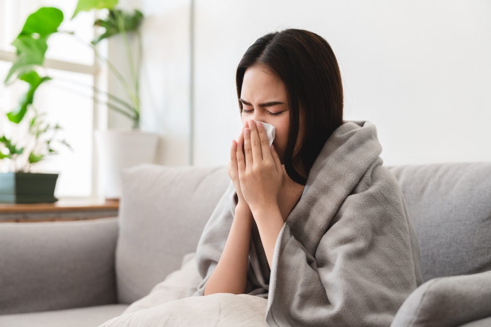Woman blowing her nose, seeking relief from cold symptoms.