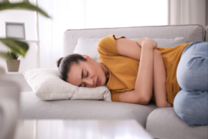 Woman resting on a couch with the stomach flu.