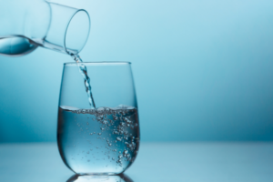 Pouring a glass of water for daily hydration.