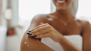 Woman applying magnesium lotion to her skin to promote skin health.