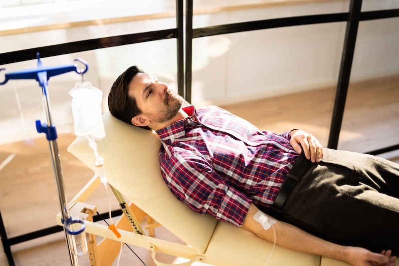 Man receiving Myers Cocktail IV Drip in a comfortable setting.