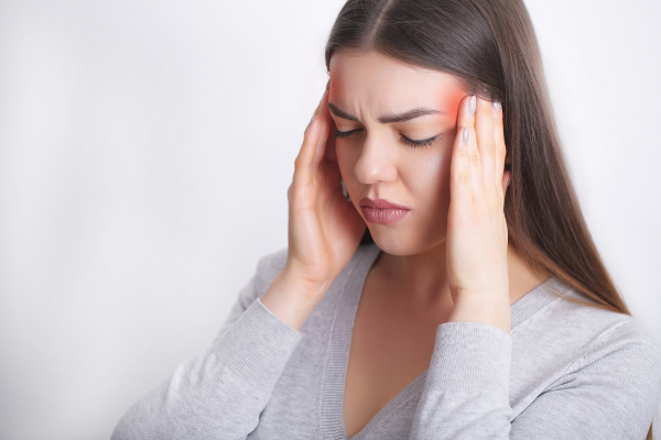 Woman holding her head in pain due to a migraine headache