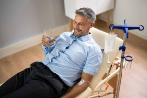 Man receiving IV therapy for headache relief while relaxing