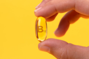 A hand holding a B12 vitamin capsule, illustrating the oral supplement option for B12.