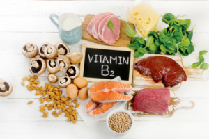 Assortment of foods high in B complex vitamins, including leafy greens, whole grains, nuts, and dairy products.