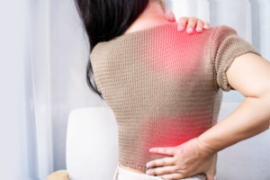 A woman experiencing nerve pain in her shoulder with highlighted red area.